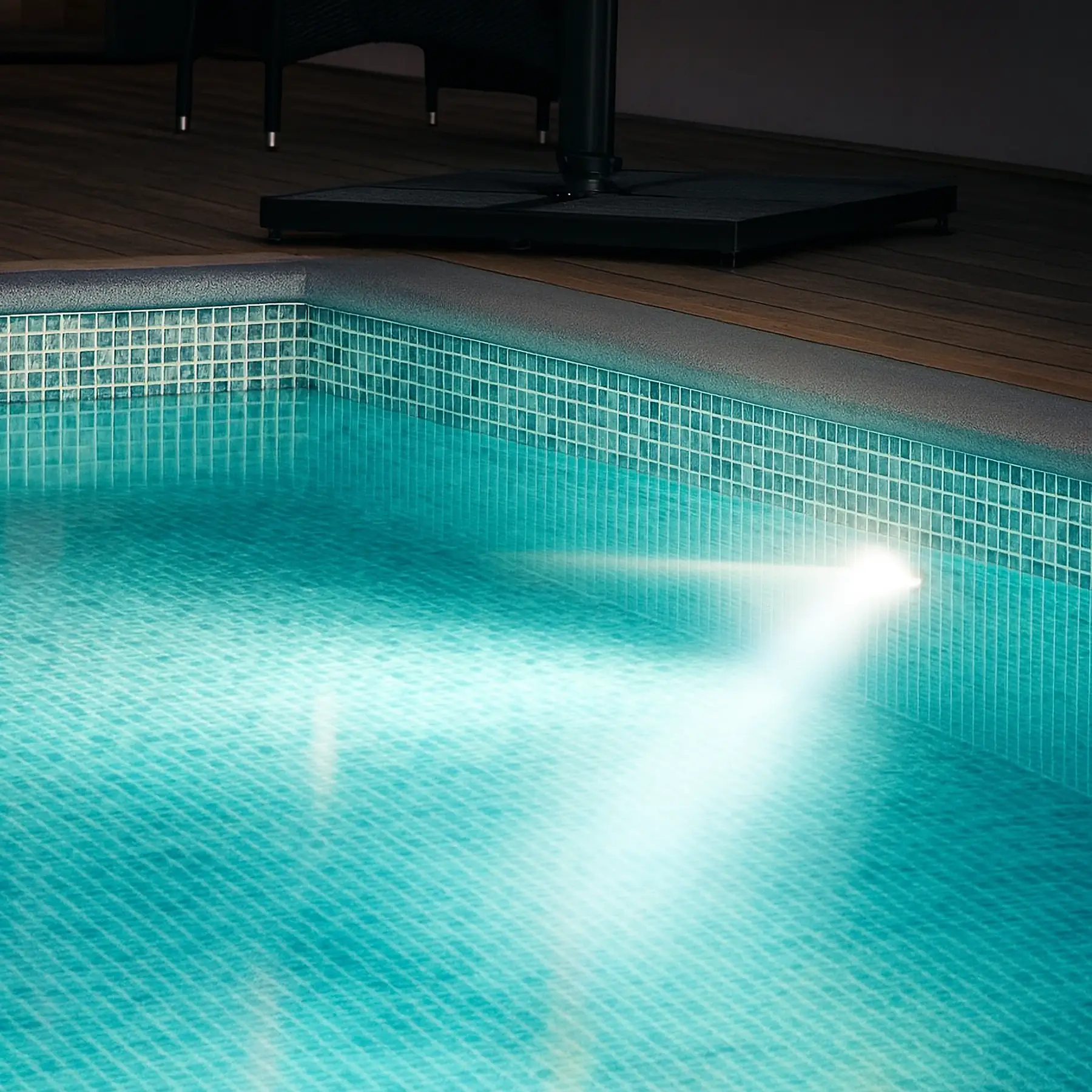 Kvällsbild på en poolbelysning som skapat en inbjudande atmosfär runt poolen