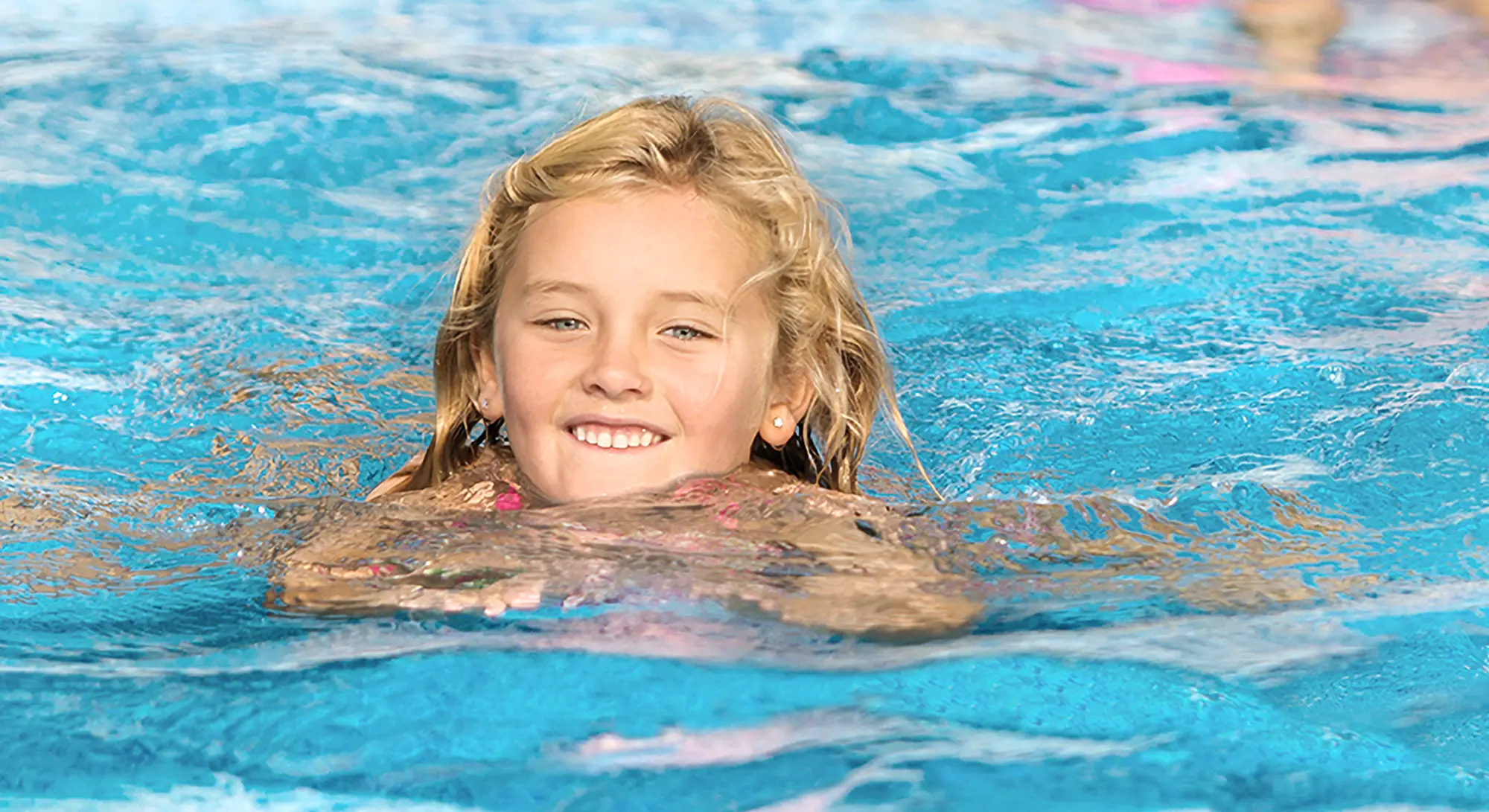 Ett av familjen Wennerlöfs barn badande under vår kundintervju om deras pool och val av leverantör